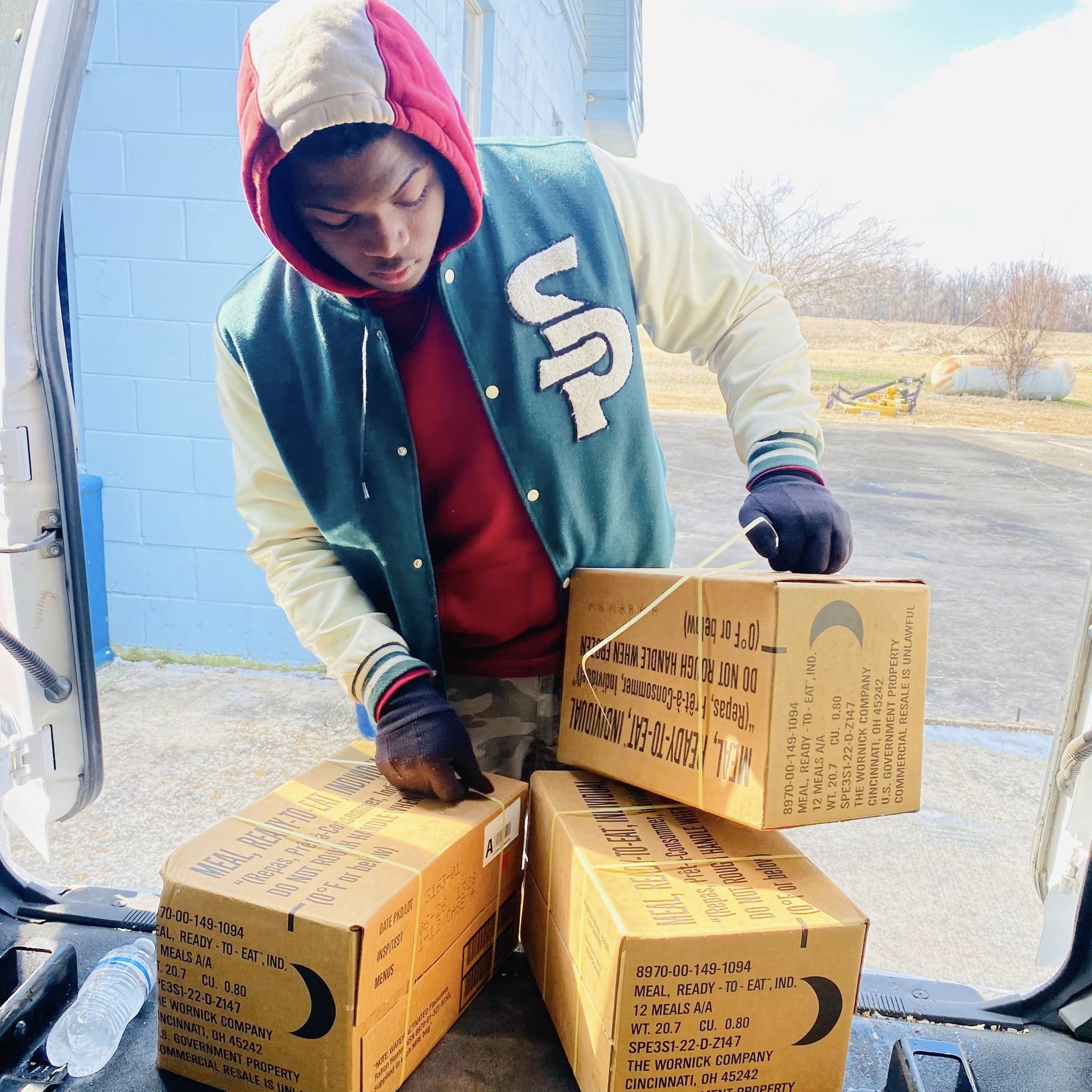 A man picking up boxes.